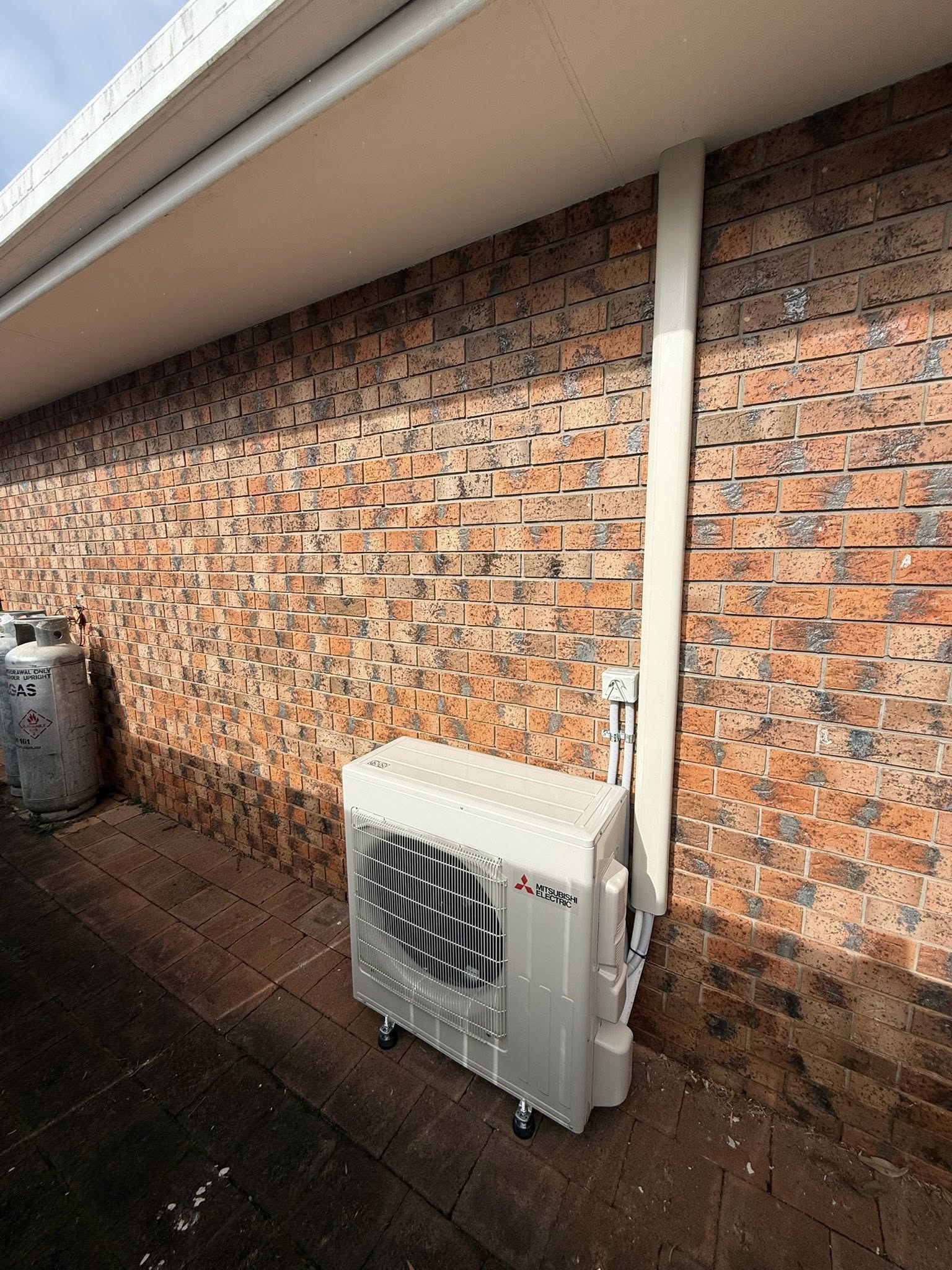 Newly installed Mitsubishi Electric outdoor condenser unit with tidy pipework